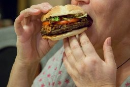 Woman_eating_a_cheeseburger