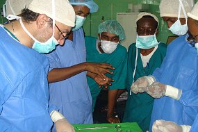 A group of doctors and nurses wearing protective facial masks and gowns in the operating theatre