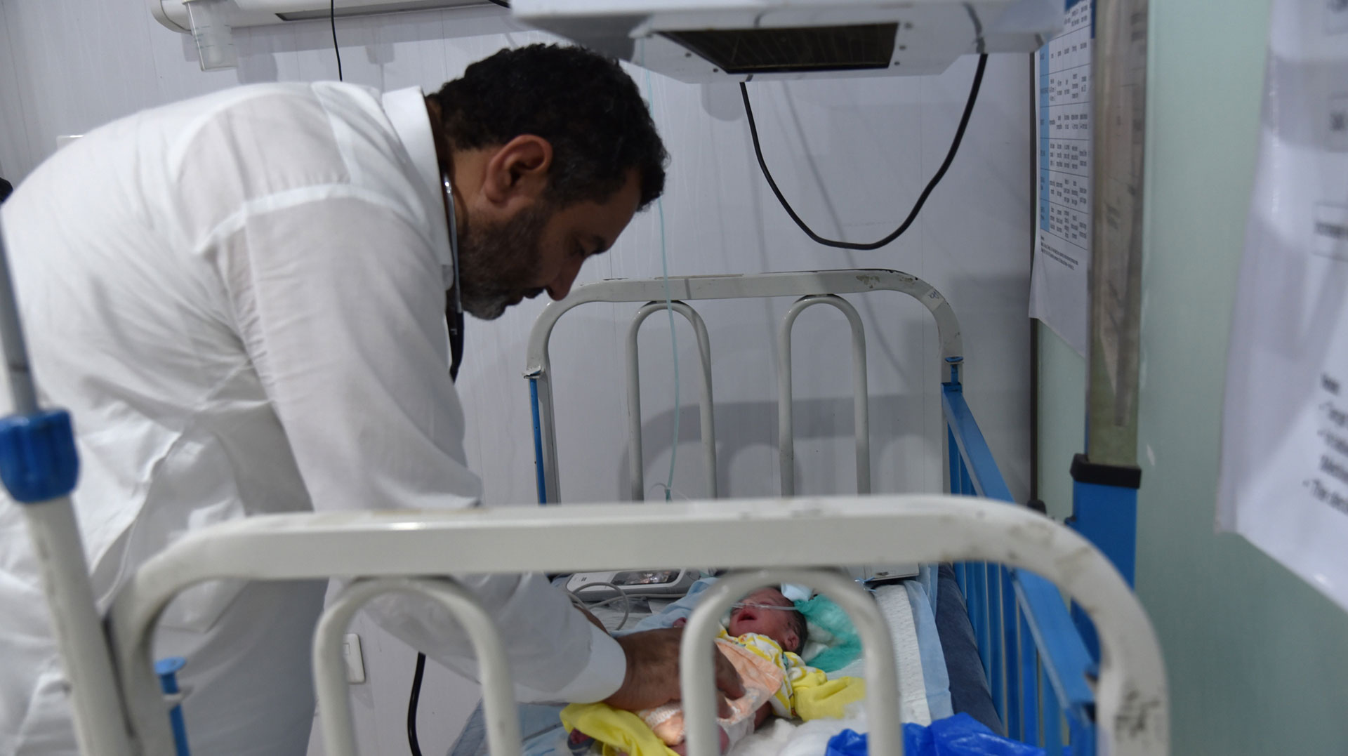 Dr Muhammad Iqbal checking a newborn at Haripur District Headquarters Hospital.   Photo: Sara Akmal/WHO Pakistan 
