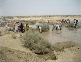 People crossing the Johi-Wahi road at the point of destruction