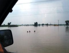People wade through very deep water in Kasur, Punjab, Pakistan, following flash floods.