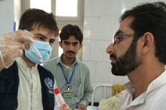 WHO’s DEWS surveillance officer is inspecting a disease sample at health facility in  Bannu,  Khyber Pakhtunkhwa