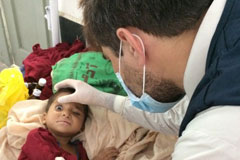 A WHO surveillance officer examines a child in a hospital in Bannu, Khyber Pakhtunkhwa