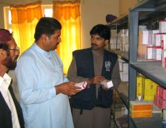 Health staff checking medicines in a pharmacy storeroom