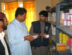 Health staff checking medicines in a pharmacy storeroom