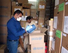 Health staff in a warehouse checking medicines