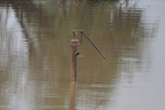 A hand pump appears just above flood water in Badin, Sindh