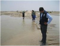 WHO staff member surveys the flooding of the Johi-Chinni road