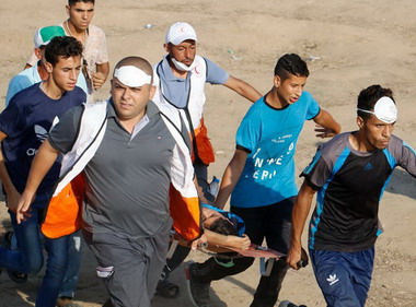 Injured man carried on stretcher during Gaza demonstrations