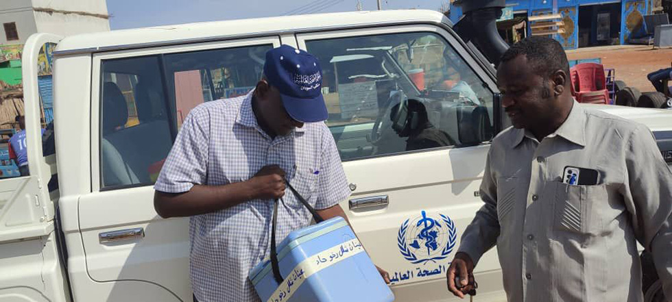 Photo 3 - Dr Ameir Ibrahim, WHO Public Health Officer of Gezira State (right), and the State Cold Chain Officer of the Ministry of Health checking that stool samples are stored at optimum temperature. WHO/Sudan 