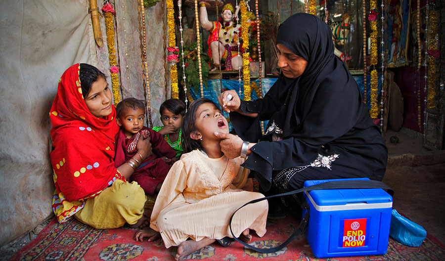 Un agent de santé vaccine un enfant de la communauté hindoue contre la poliomyélite, devant leur lieu de culte, situé dans sa maison, lors de la Journée nationale de vaccination contre la poliomyélite à Bhakkar, dans la ville de Gulshan-e-Iqbal, à Karachi (Pakistan).