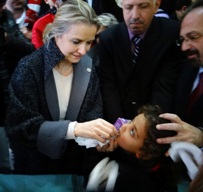 L’image nous montre la Représentante de l’OMS en Syrie, Elizabeth Hoff, administrant le vaccin antipoliomyélitique oral à un enfant