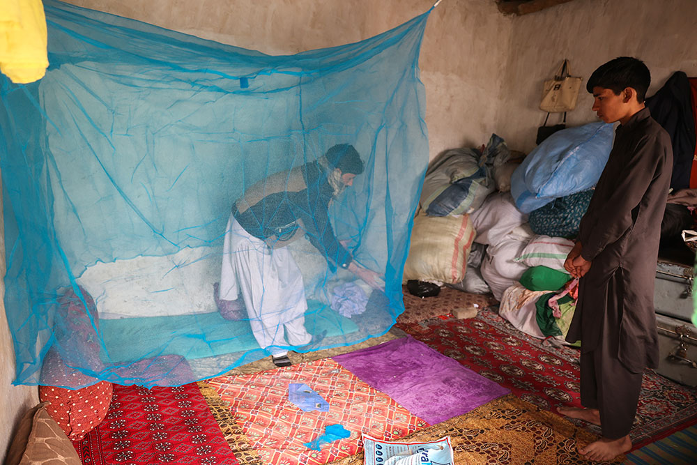 A local resident in Chahar Misra village, Behsud, Nangarhar, puts up a bed net. Photo credit: WHO/WHO Afghanistan 