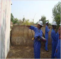 A group of technicians performing indoor residual spraying 