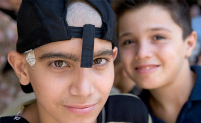 Photo de deux visages de jeunes garçons en gros plan, l'un d'entre eux portant une casquette à l'envers