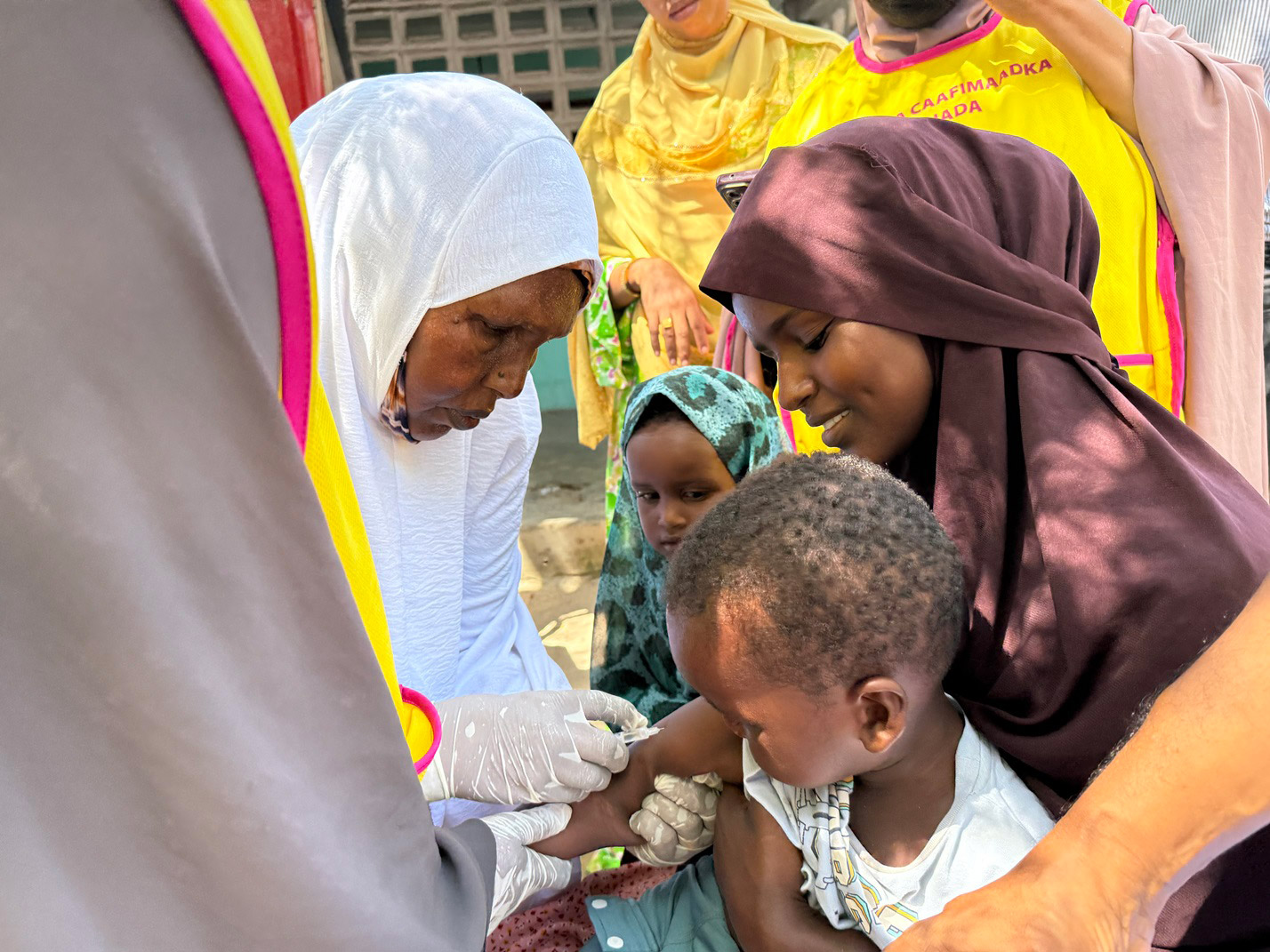 A health worker vaccinates a child during a community immunization drive.