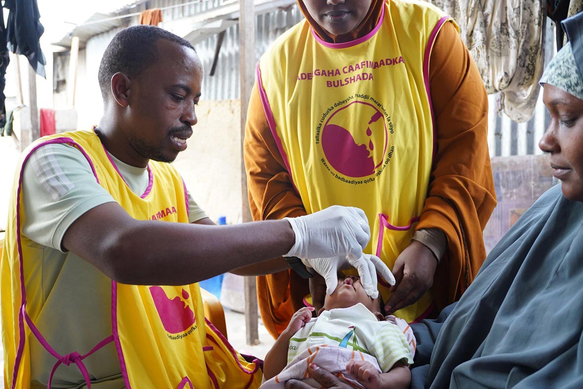 A health worker vaccinates an infant against cholera during a community outreach campaign, ensuring protection for the most vulnerable in hard-to-reach areas.