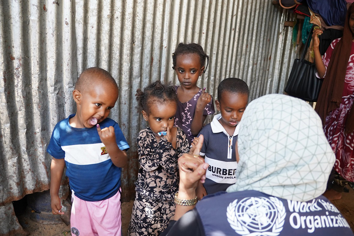 Children show their marked fingers after receiving oral polio vaccine, a sign they’ve been protected during a door-to-door vaccination campaign.