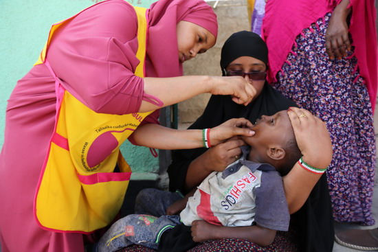 A_vaccinator_provides_2_doses_of_the_oral_polio_vaccine_to_3_yr_old_Ali_Adan_Hargeisa_2019_2