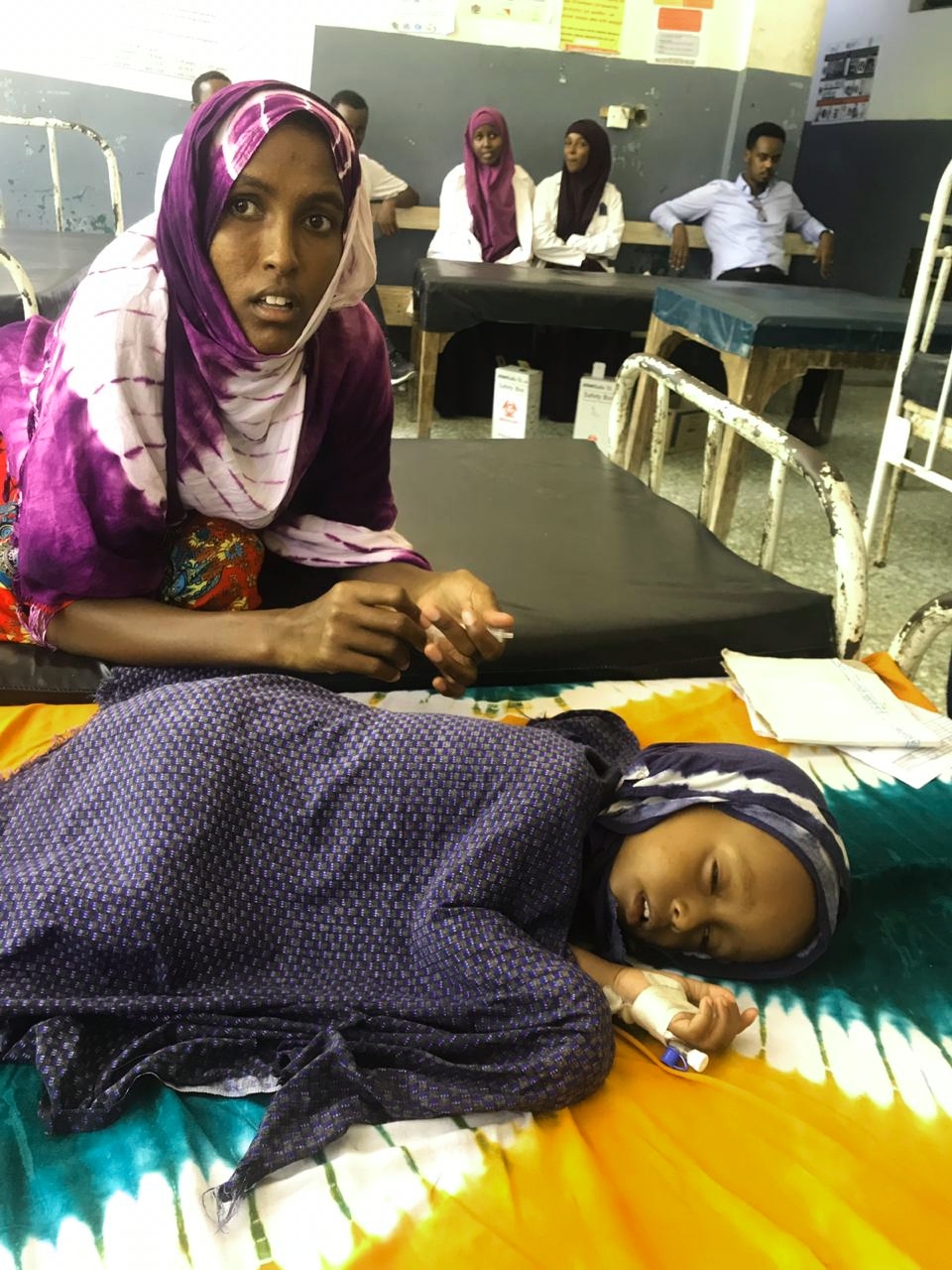 Somalia mother watches over her daughter in a treatment centre
