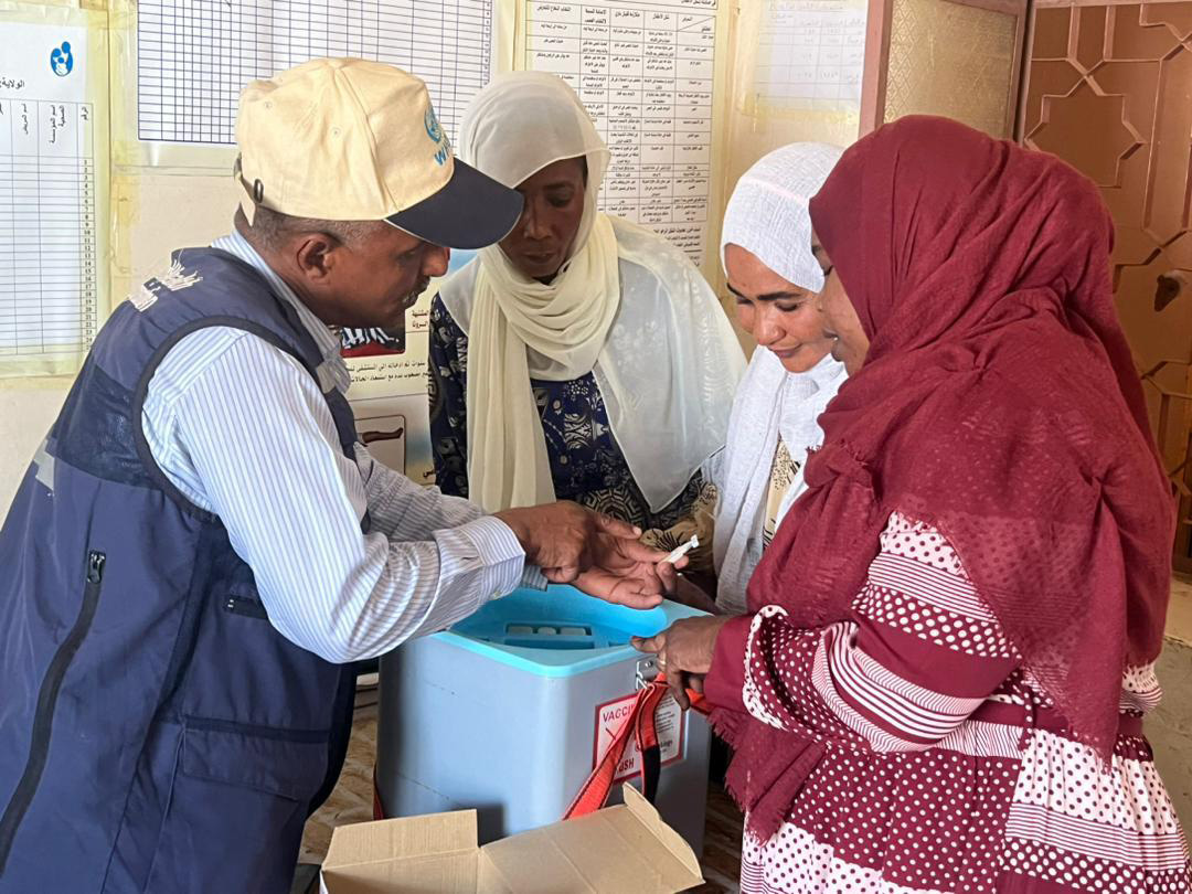 A WHO staff member trains local health workers on proper cholera vaccine handling and administration techniques in Sudan, ensuring readiness for effective outbreak response.