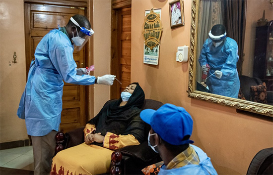 A laboratory technician on a COVID-19 rapid response team conducts a PCR test at a home in Khartoum.  © WHO/Lindsay Mackenzie