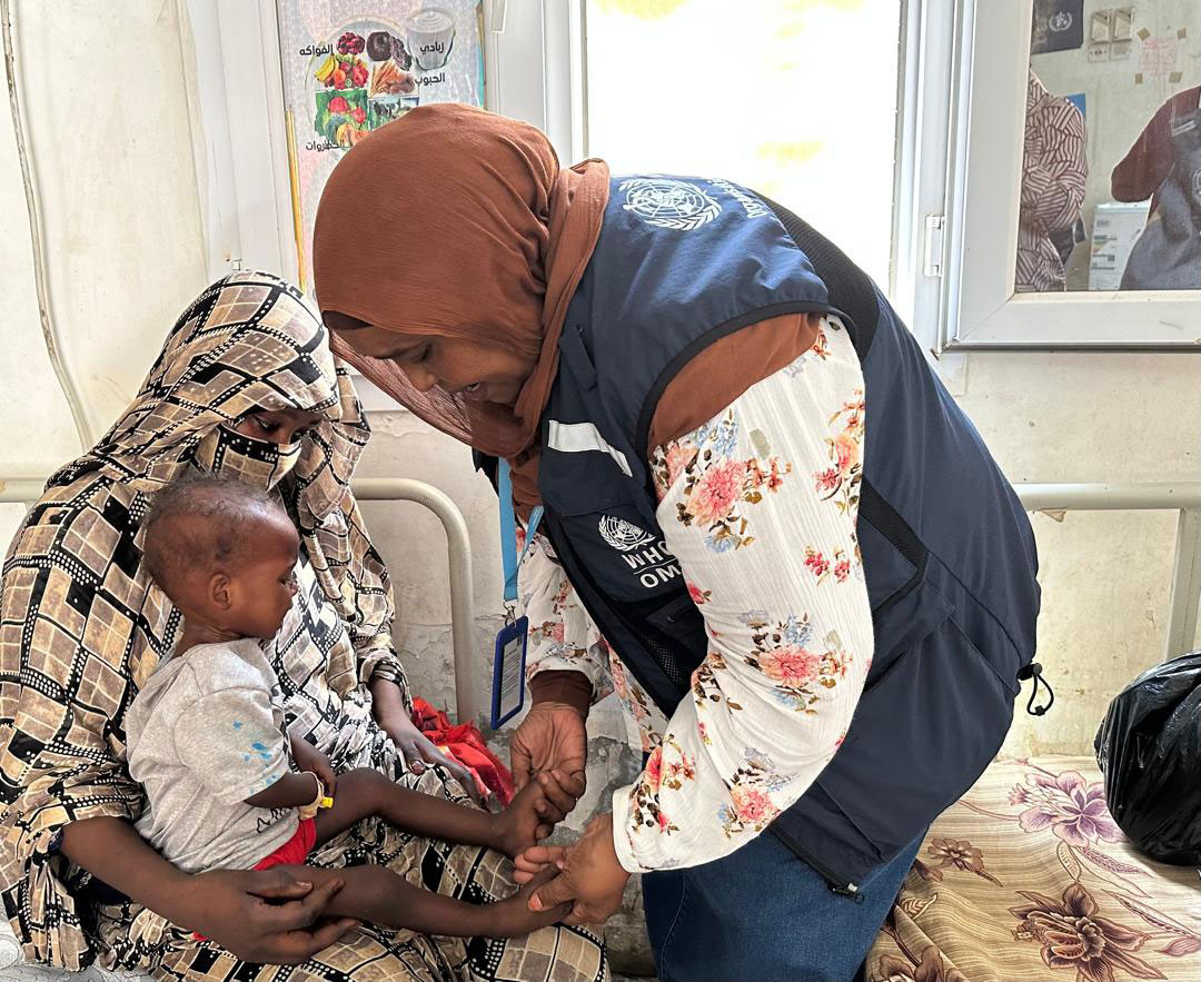 WHO Sudan nutrition officer Sara Ebed checks on Aysha, a patient at Port Sudan Stabilization Centre. Photo credit: WHO/ Loza M Tesfaye 