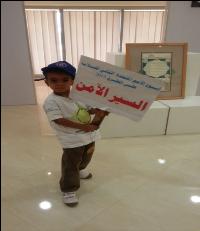 A young Sudanese boy holds up a banner promoting Road Safety Week