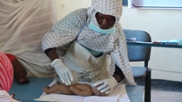 A midwife practises some recently learnt skills on a training doll