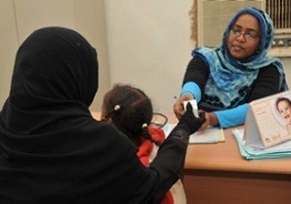 A photo shows mother and child receiving treatment and care at a health centre in Khartoum.