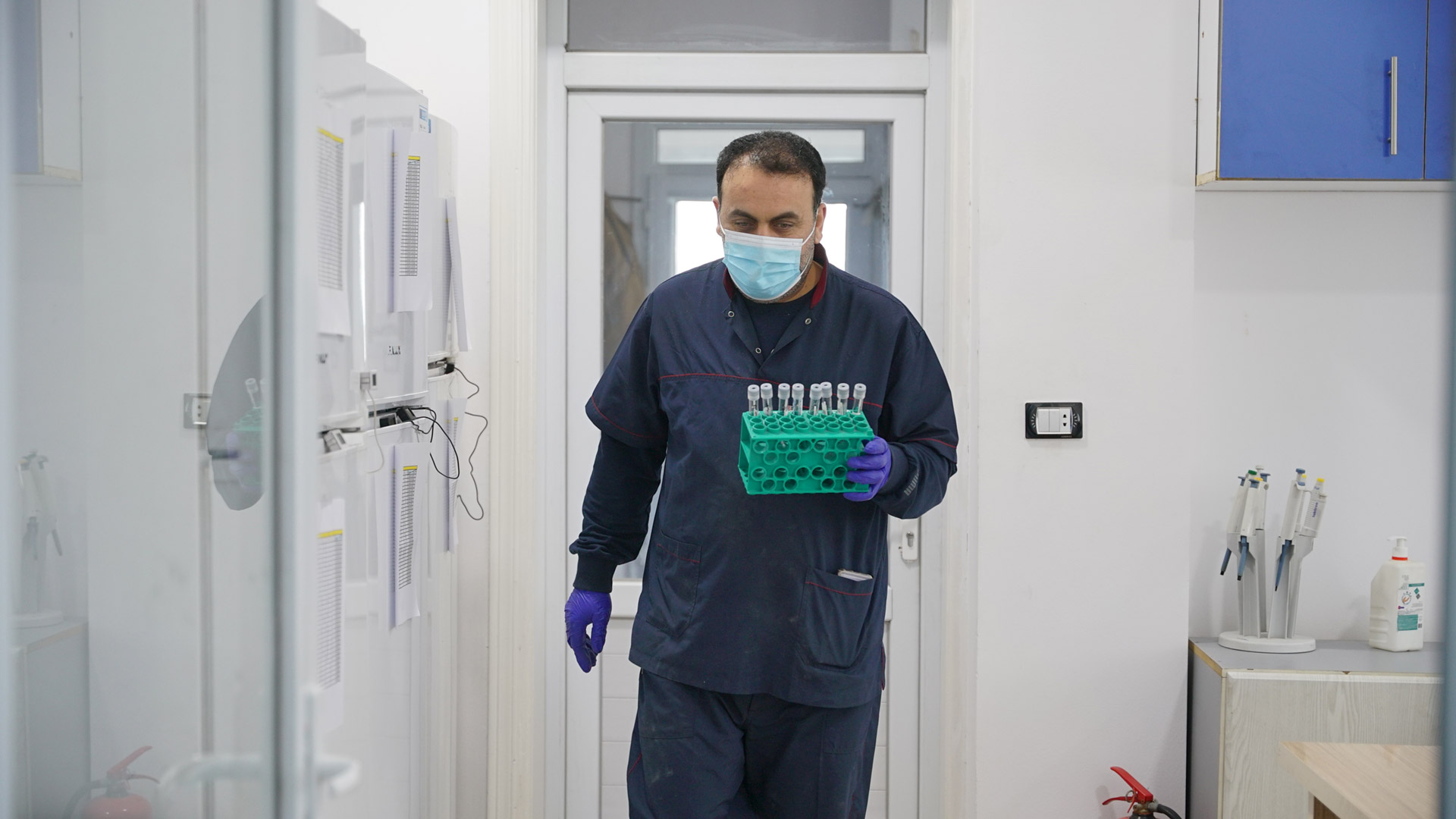 A technician carries samples for analysis at an EWARN laboratory supported by WHO. Photo credit: WHO