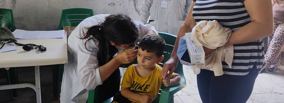 Dr Khairiya Hijazi examines a young boy during a consultation at a mobile health point in Lattakia, where she supports families with pediatric care