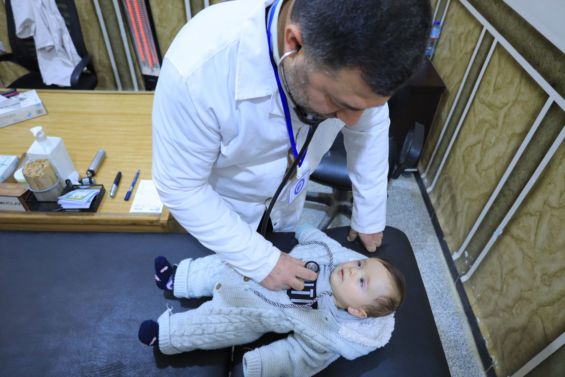 Dr Khalid Al-Rashwani examines Walid Al-Ahmad at Kurin Health Centre in Idlib. Photo credit: WHO