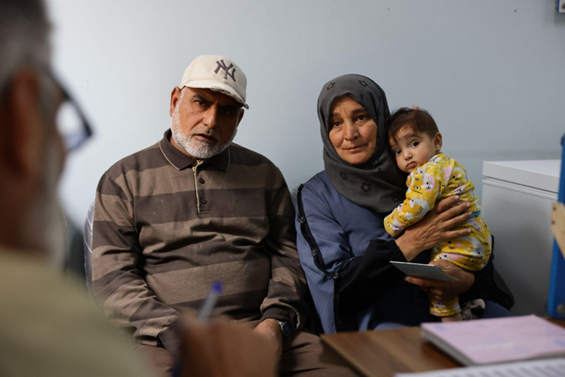 Hasan, a father of seven, speaks with Jamal before his children receive routine vaccines. Photo: WHO Hasan, a father of seven, speaks with Jamal before his children receive routine vaccines. Photo: WHO
