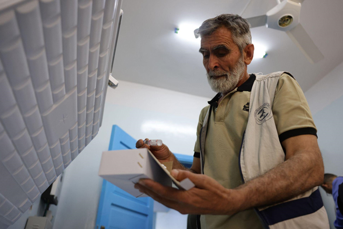 Jamal checks a vaccine dose before administering it to children during outreach in Khan Shaykhun. Photo: WHO