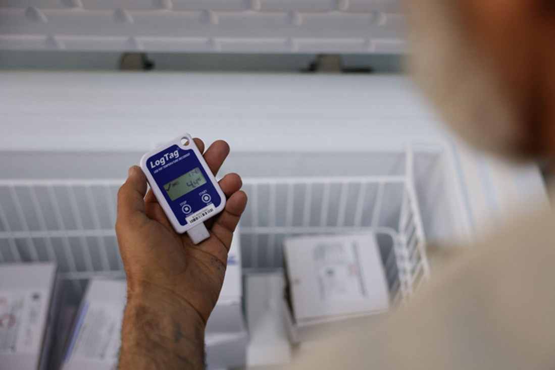 Jamal monitors the temperature of a vaccine to ensure it is safe for use during a vaccination session. Photo: WHO
