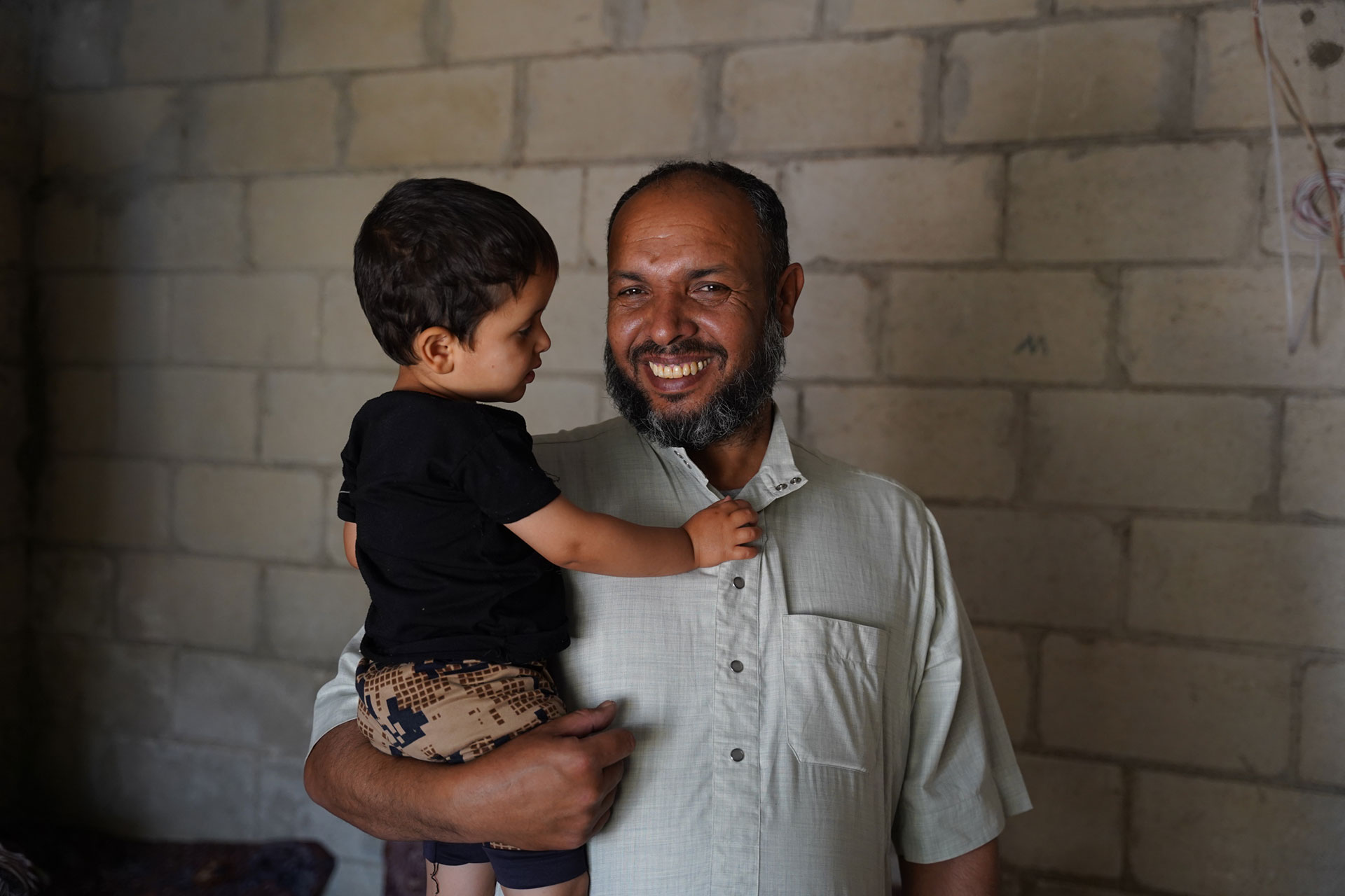 Jameel, displaced from Homs and now living in Idlib, holds his son after ensuring all his children received their vaccines. Photo: WHO