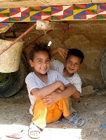 Two healthy Egyptian children smiling at the camera