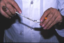 A doctor filling a syringe from a phial of meglumine antimoniate, used for the treatment of cutaneous leishmaniasis