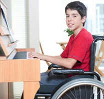 A boy in a wheelchair playing a piano