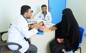Mother and infant with health staff at clinic