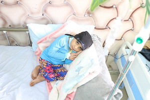 A young girl lying on a hospital bed