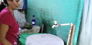 غطي المرأة وعاء مفتوح من الماء لمنع البعوض تربية ونشر مرض فيروس زيكا