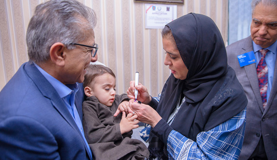 Regional director vaccinating Pakistani child against polio Regional director vaccinating Pakistani child against polio