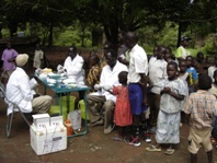 A group of people in South Sudan receiving active screening for sleeping sickness from health staff