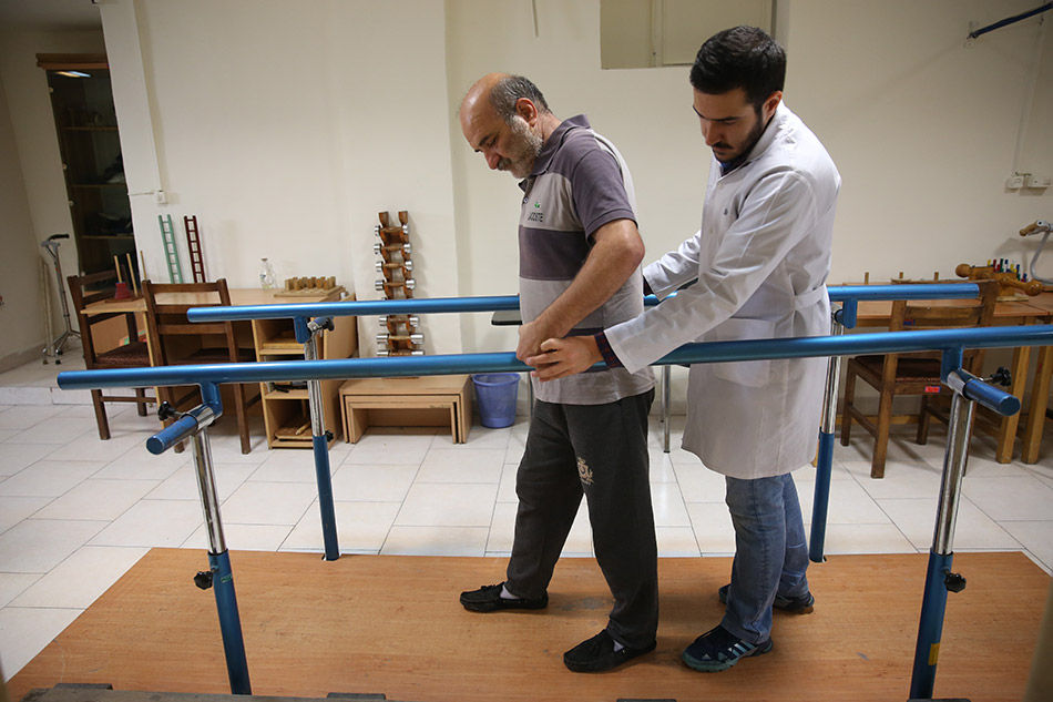 A health care worker helps a man with disability complete his physiotherapy exercises. Photo: Mr Akbar Badrkhani, Shahid Beheshti University of Medical Sciences, Tehran, Islamic Republic of Iran