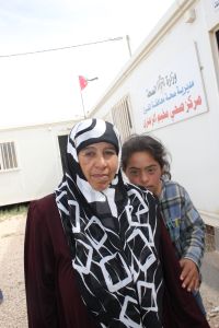 Fatmah, a 14-year-old Syrian refugee, stands behind her mother at Al Zaatari camp