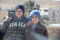 Two young Jordanian boys smiling at the camera
