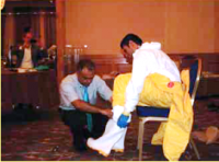 Trainer assisting a health staff to wear a personal protective equipment