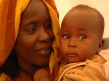 A Sudanese mothers smiles at her child in her arms
